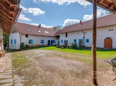Dvůr s historickými zemědělskými budovami, kamenná dlažba, staré dřevěné vrata, rekonstrukce původního stylu. | Prodej - zemědělský objekt, 33 224 m²