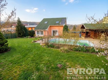Zahrada s bazénem, udržovaný trávník a altán. Rodinný dům má moderní architekturu a velká okna, nachází se v klidné lokalitě. | Prodej - dům/vila, 260 m²