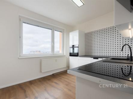 Moderní kuchyň s parketovou podlahou, velkým oknem a černobílými obklady. Světlý prostor s vestavěnými spotřebiči. | Prodej bytu, 2+1, 58 m²