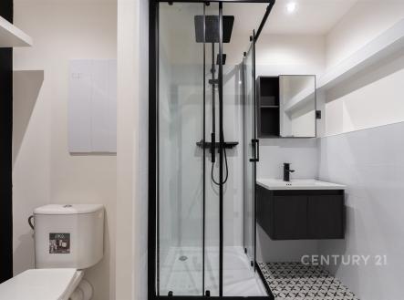 Moderní koupelna s černými doplňky, sprchovým koutem a stylovými obklady. Nově zrekonstruovaná, nabízí elegantní a praktický design. | Prodej bytu, 2+1, 58 m²