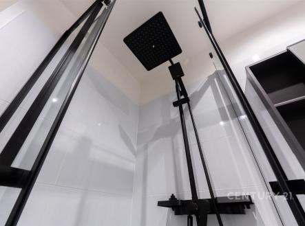 Moderní sprchový kout s černými skleněnými dveřmi, elegantním dešťovým sprchovým panelem a světlými keramickými obklady | Prodej bytu, 2+1, 58 m²