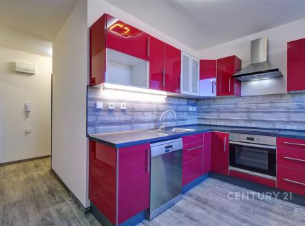 Moderní kuchyň s parketovou podlahou, červenými lesklými skříňkami a vestavěnými spotřebiči, včetně myčky a trouby, nabízí svěží design. | Prodej bytu, 2+1, 58 m²