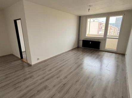 Světlý obývací pokoj s laminátovou podlahou, velká okna, světlý interiér, výhled na město, moderní styl, renovovaný prostor. | Pronájem bytu, 3+1, 69 m²