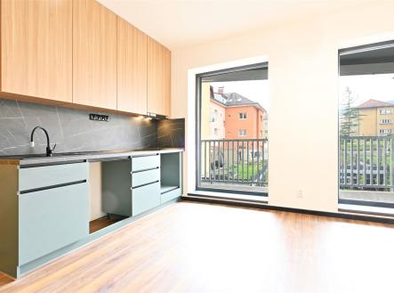 Moderní kuchyň s parketovou podlahou, vestavěnými skříněmi a velkými okny prosvětlujícími prostor. | Pronájem bytu, 3+kk, 68 m²