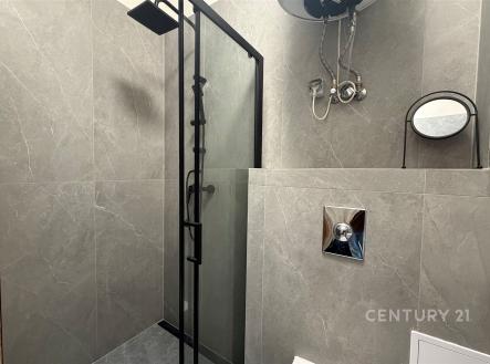 Moderní koupelna s keramickými obklady, sprchovým koutem a elegantními kovovými detaily. | Prodej bytu, 2+1, 43 m²