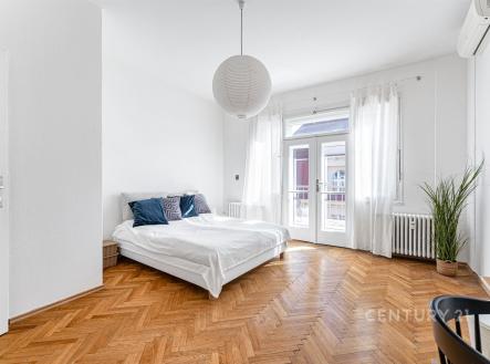 Prostorná ložnice s parketovou podlahou, velkými okny a moderní klimatizací, nabízí světlo a styl v rekonstruovaném bytě. | Pronájem bytu, 1+1, 64 m²