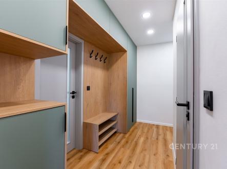 Chodba s dřevěnou podlahou, vestavěné skříně v moderním designu, stropní osvětlení zajišťující světlost prostoru. | Prodej bytu, 3+kk, 54 m²