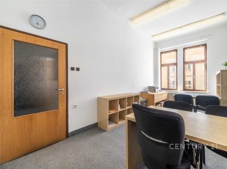 Kancelářský prostor s kobercovou podlahou, velkými okny a moderním vybavením. Světlá místnost nabízí pohodlné prostředí pro práci. | Pronájem - kanceláře, 59 m²
