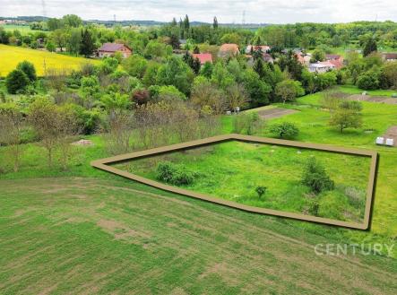 Pohled na stavební pozemek obklopený zelení, rovinatý terén, klidná lokalita, v blízkosti vesnické zástavby, ideální pro rodinný dům. | Prodej - pozemek pro komerční výstavbu, 1 463 m²