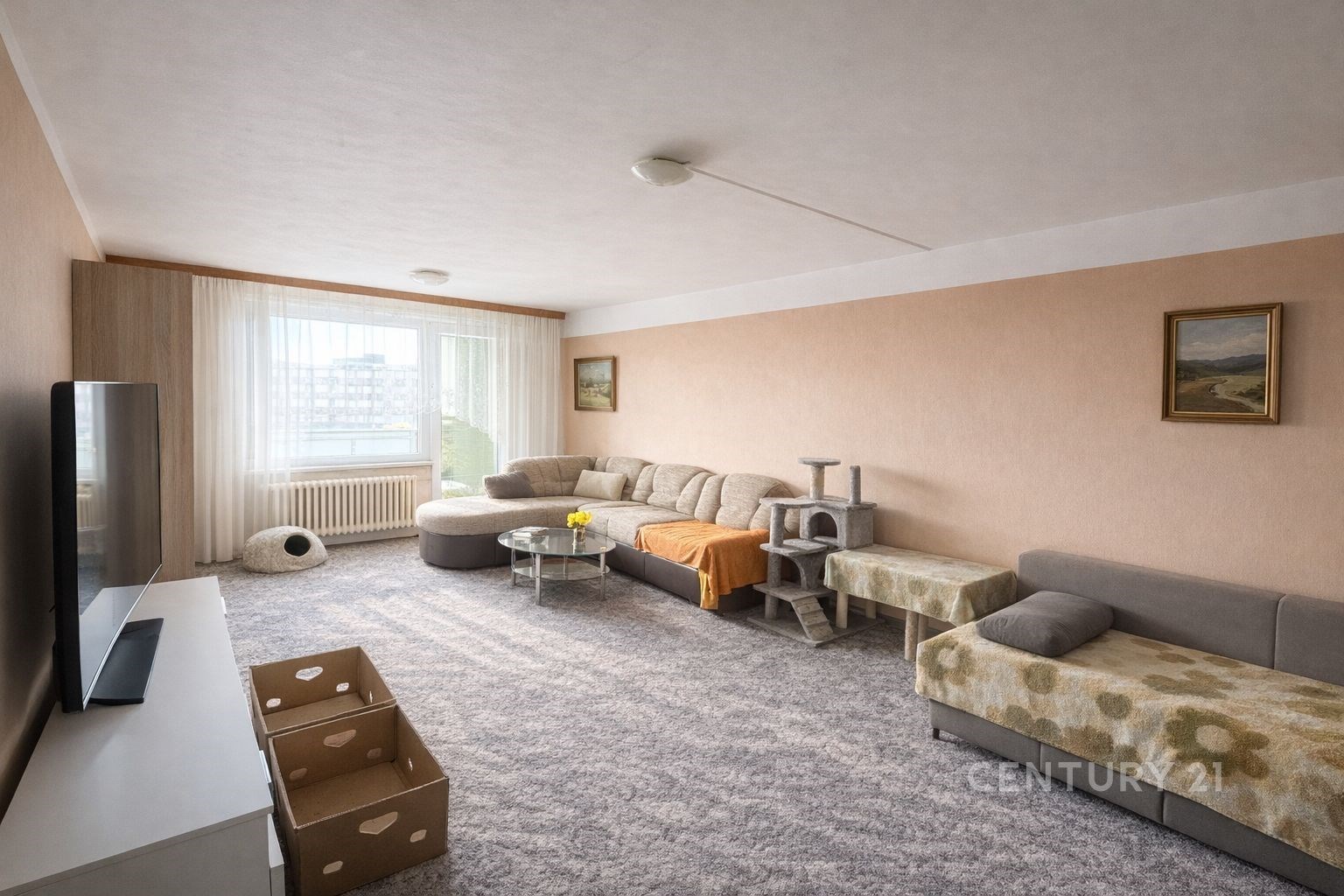 Prostorný obývací pokoj se světlým koberce, velkými okny a útulným nábytkem, nabízí světlý interiér s moderním designem.