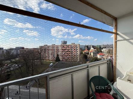 Balkon s výhledem na městskou zástavbu, kovové zábradlí, bezpečnostní síť, slunečné počasí, vhodné pro venkovní posezení | Prodej bytu, 1+1, 45 m²
