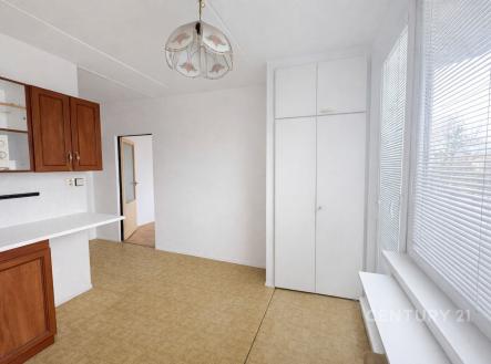 Světlá kuchyň s parketovou podlahou a vestavěnými skříněmi, doplněná velkými okny pro přirozené světlo, v moderním stylu. | Prodej bytu, 1+1, 32 m²