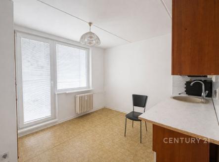 Světlá kuchyň s laminátovou podlahou, velkými okny a vestavěným radiátorem nabízí moderní prostor ideální pro rekonstrukci. | Prodej bytu, 1+1, 32 m²