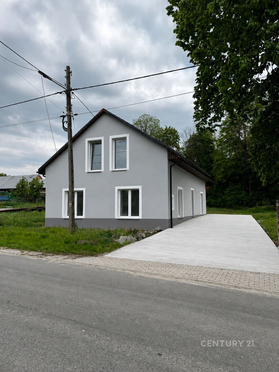 Moderní rodinný dům s bílou fasádou a novou příjezdovou cestou, plastová okna a klidná lokalita poblíž lesa