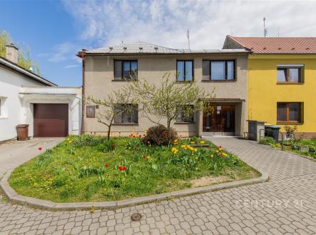 Rodinný dům s tradiční fasádou, upravenou zahradou a garáží. Přístupová cesta je z dlažby. Dům má moderní okna a udržovaný exteriér. | Prodej - dům/vila, 160 m²
