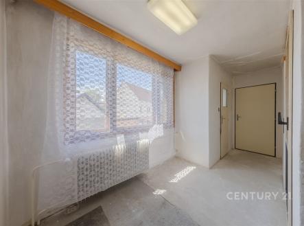 Průchozí místnost s velkými okny, stěnami v surovém stavu a betonovou podlahou, vhodná k rekonstrukci. | Prodej - dům/vila, 160 m²