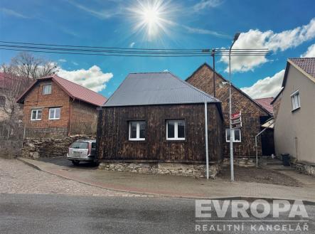 Venkovní pohled na rekonstruovaný dům s dřevěným obkladem, plechovou střechou a plastovými okny, situovaný na klidné ulici | Prodej - dům/vila, 200 m²