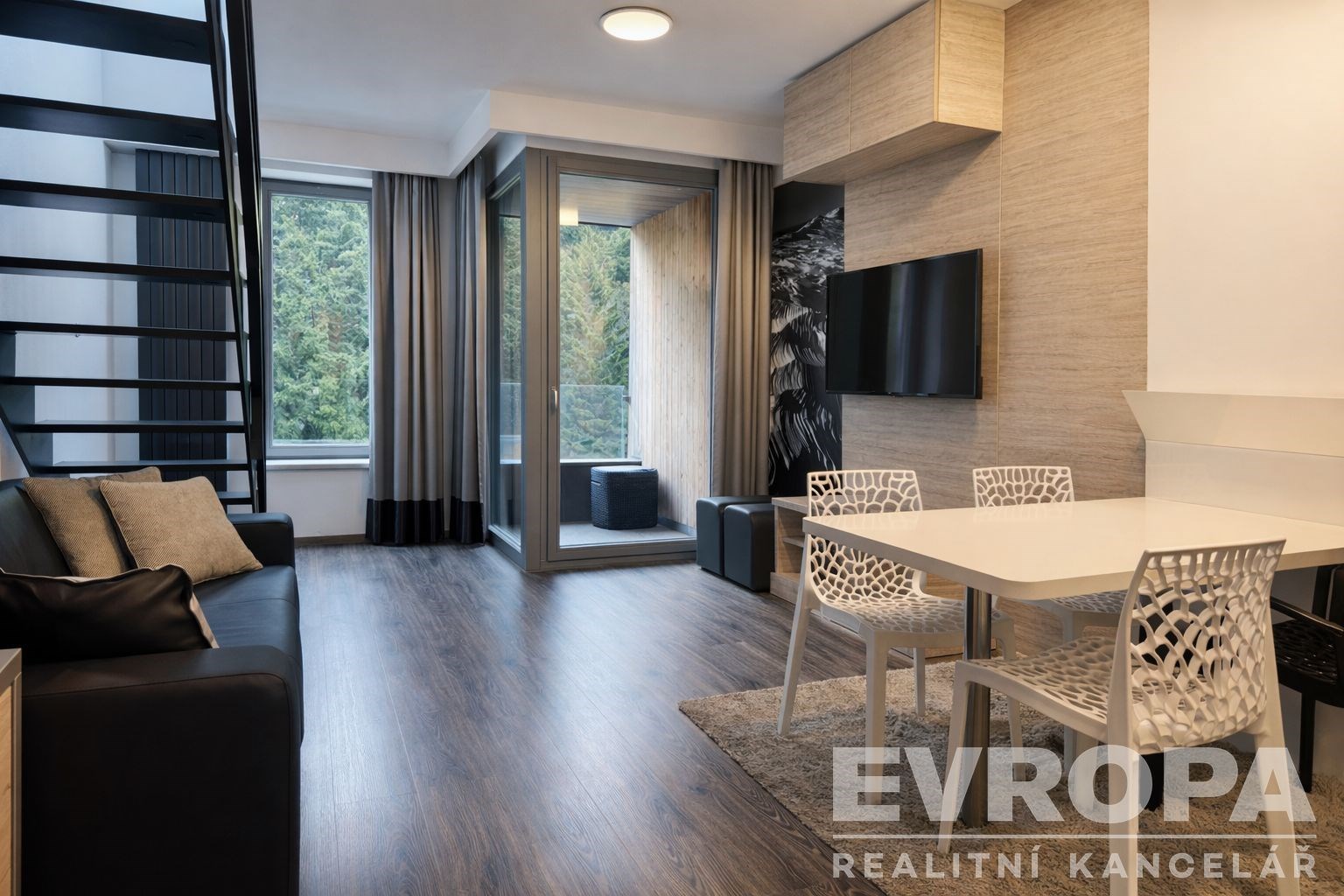 Moderní obývací pokoj s parketovou podlahou, velkými okny a stylovým nábytkem. Loftový design dodává prostoru svěží a světlý vzhled.