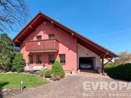 Růžový rodinný dům s prostornou garáží, dlážděný příjezd a udržovaná zahrada, dřevěný balkon a moderní vzhled pro pohodlné bydlení. | Prodej - dům/vila, 229 m²