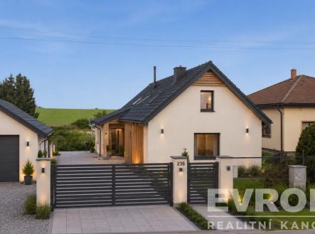 Moderní rodinný dům s elegantní fasádou, velká okna a upravená zahrada, nacházející se v klidné oblasti s garáží a dlážděným příjezdem. | Prodej - dům/vila, 85 m²
