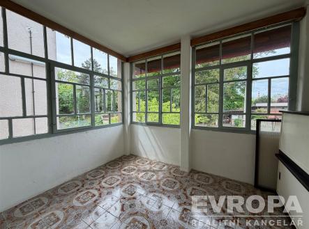 Zasklená lodžie s dlažbou, výhledem do zeleně a velkými okny, nabízí světlý prostor k relaxaci. | Pronájem bytu, 1+kk, 27 m²