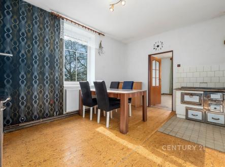 Světlá jídelna s korkovou podlahou, velká okna propouštějí přirozené světlo, vedle moderní kuchyně s původními kamny. | Prodej - dům/vila, 128 m²