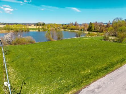 Stavební pozemek s výhledem na klidné jezero, obklopený zelení a situovaný poblíž veškeré infrastruktury, ideální pro rodinný dům. | Prodej - pozemek pro bydlení, 1 863 m²
