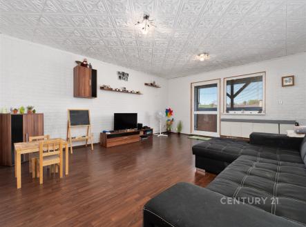 Prostorný obývací pokoj s parketovou podlahou, velká okna zajišťují světlost, moderní stropní design a komfortní sedací souprava pro relaxaci. | Prodej bytu, 3+1, 78 m²