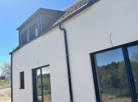 Moderní fasáda domu, velká okna, výhled na přírodu, kvalitní izolace, energeticky úsporný design, kombinace dřeva a omítky | Prodej bytu, 4+kk, 112 m²
