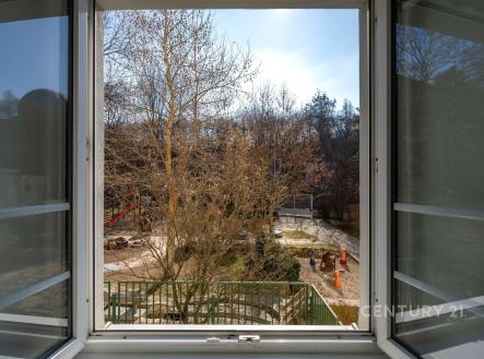 Výhled z okna na udržovanou zahradu s dětským hřištěm, velká okna, klidná lokalita, ideální pro rodiny s dětmi. | Pronájem bytu, 2+1, 57 m²