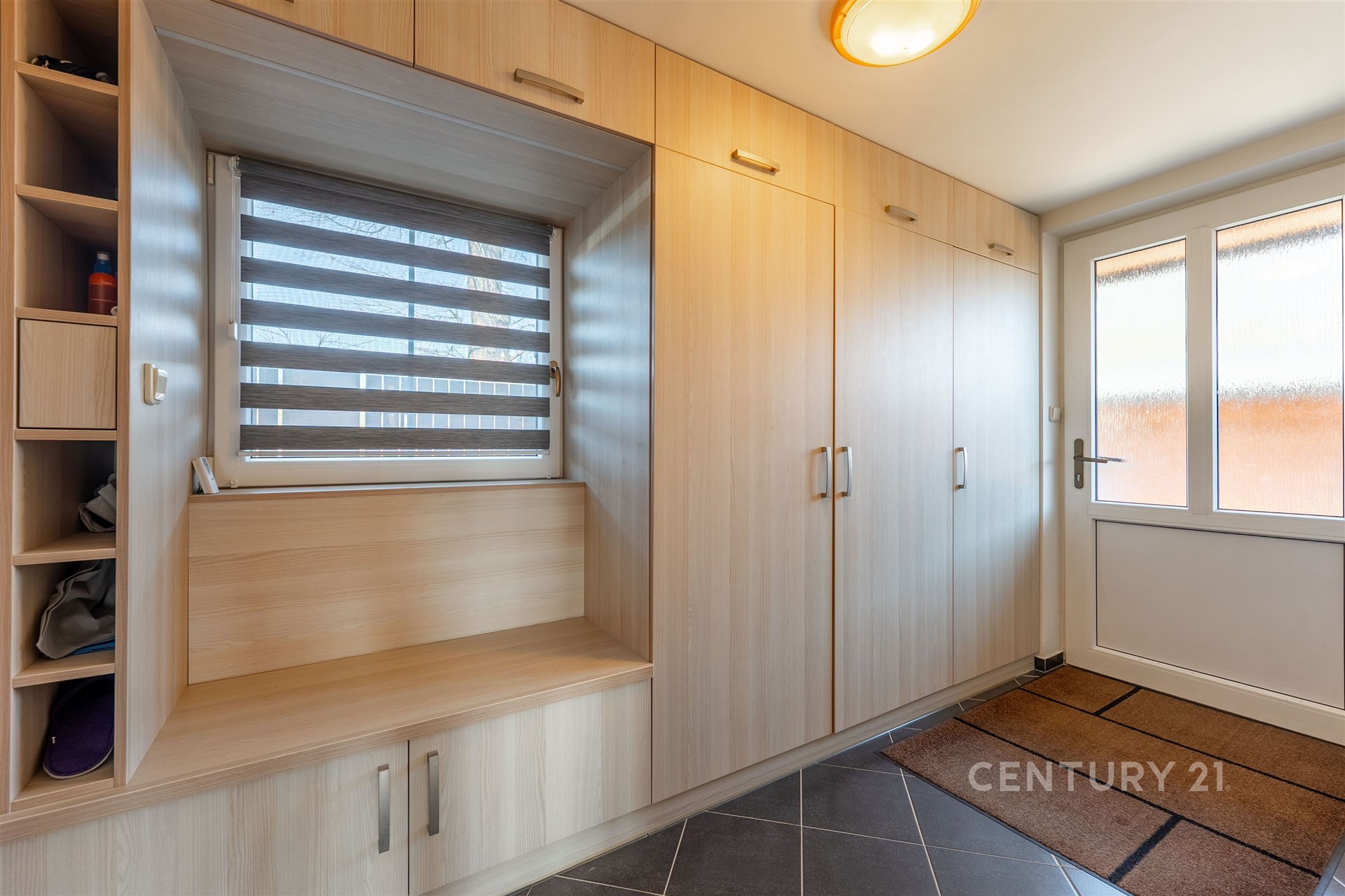 Vstupní hala s vestavěnými skříněmi, dlažba na podlaze a moderní osvětlení, poskytuje praktické úložné prostory a elegantní design.