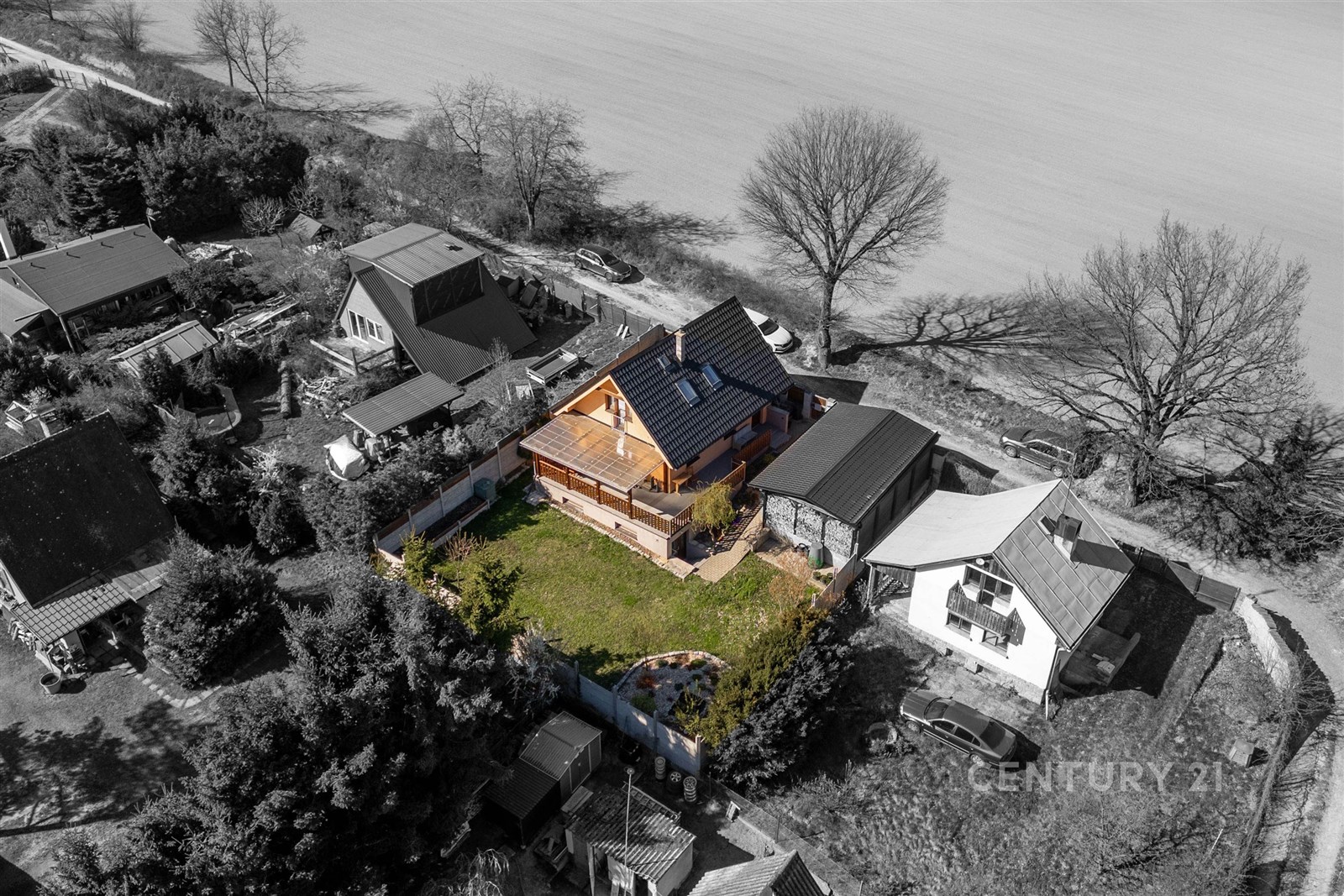 Rodinný dům s moderní střechou a velkou terasou, obklopený udržovanou zahradou. Klidná lokalita, prostorný pozemek, ideální pro rodinné bydlení