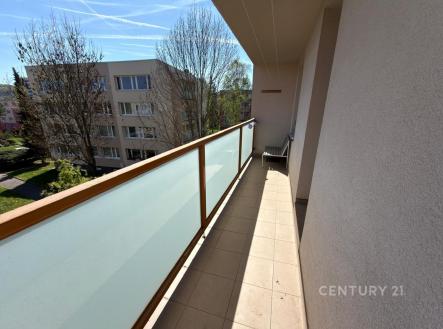 Prostorný balkon s dlažbou a moderním zábradlím nabízí výhled na klidné okolí a vzrostlé stromy, ideální pro relaxaci na čerstvém vzduchu. | Pronájem bytu, 3+kk, 67 m²