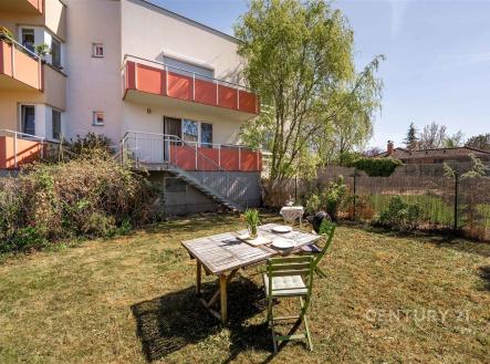 Udržovaná zahrada s venkovní terasou, stůl s židlemi, vhodné pro relaxaci. Klidná lokalita, ideální pro rodinné bydlení. | Pronájem bytu, 1+kk, 35 m²