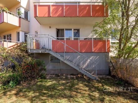 Balkon s kovovým zábradlím, vstupem do bytu, orientován na jih, obklopený zelení, ideální pro relaxaci nebo letní stolování. | Pronájem bytu, 1+kk, 35 m²