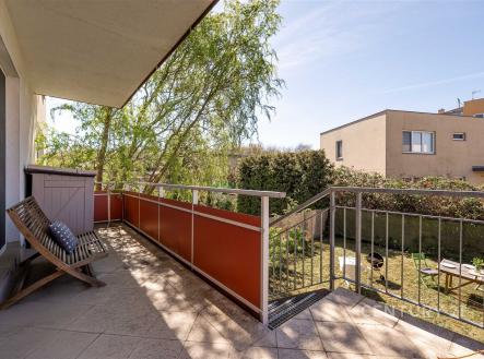 Balkon s dlažbou nabízí výhled na zahradu, moderní zábradlí a dostatek prostoru pro venkovní posezení, ideální pro relaxaci na čerstvém vzduchu. | Pronájem bytu, 1+kk, 35 m²