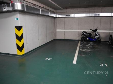 Garážové stání s betonovými stěnami a číslovanými parkovacími místy, vhodné pro auto nebo motocykl, dobře osvětlené a prostorné | Pronájem - malý objekt/garáž