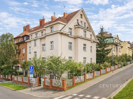 Vícepatrový dům s červenou střechou a zahradou, který se nachází ve vilové čtvrti, ukazuje udržovaný exteriér a klidné okolí. | Prodej bytu, 2+kk, 47 m²