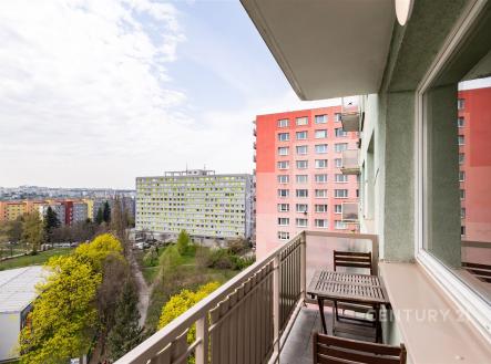 Balkon s výhledem na město, dřevěný nábytek, byt v panelovém domě, světlá fasáda a okolní zeleň vytváří příjemnou atmosféru pro relaxaci. | Pronájem bytu, 3+1, 77 m²