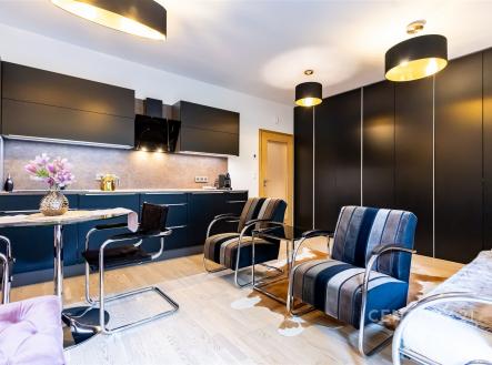 Moderní kuchyň s parketovou podlahou, vestavěné skříně a elegantní osvětlení, stylový a světlý interiér | Pronájem bytu, 1+kk, 37 m²