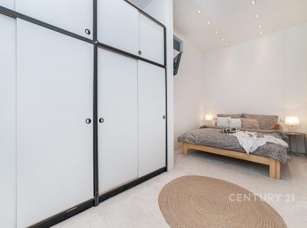 Prostorná ložnice s vestavěnými skříněmi, moderním osvětlením a kobercem, nabízí útulný a čistý design ideální pro relaxaci. | Prodej bytu, 2+1, 65 m²