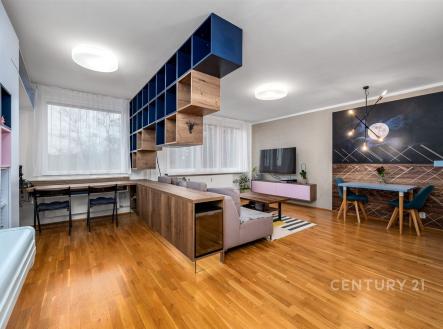 Prostorný obývací pokoj s parketovou podlahou, moderním vestavěným nábytkem a velkými okny. Elegantní otevřený koncept zajišťuje světlý interiér. | Prodej bytu, 2+kk, 78 m²