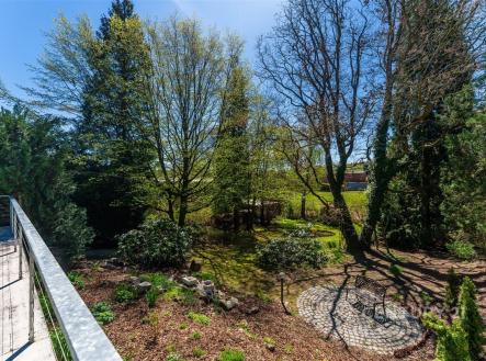 Prostorná zahrada s dlážděnou terasou, obklopená vzrostlými stromy, nabízí klidné prostředí pro relaxaci a venkovní aktivity. | Prodej - dům/vila, 110 m²