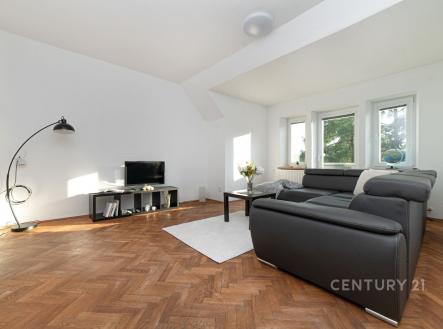 Světlý obývací pokoj s parketovou podlahou, velkými okny a moderní sedací soupravou nabízí útulný prostor pro odpočinek. | Prodej bytu, 2+1, 192 m²