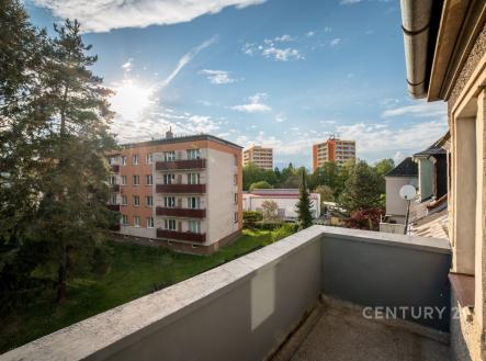 Balkón s výhledem na panelové domy, obklopený zelení. Betonová podlaha a prostorný výhled dotvářejí klidnou atmosféru moderního bydlení. | Prodej bytu, 2+1, 192 m²