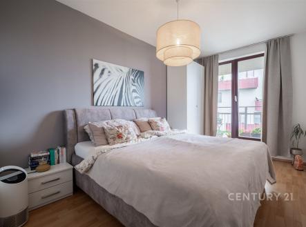 Prostorná ložnice s parketovou podlahou, velká okna poskytující dostatek světla, moderní interiér s elegantním osvětlením. | Pronájem bytu, 2+kk, 60 m²