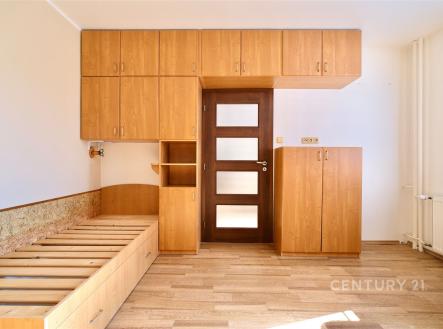 Prostorná ložnice s dřevěnými vestavěnými skříněmi, moderními dveřmi a parketovou podlahou, ideální pro uspořádané skladování. | Pronájem bytu, 3+1, 74 m²