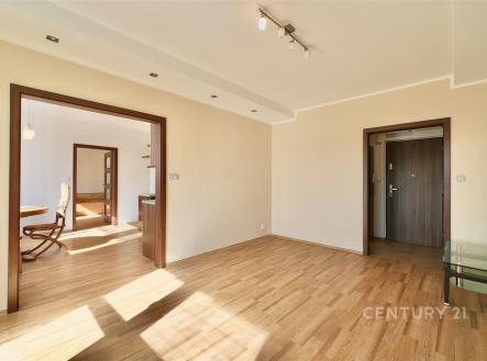 Světlý obývací pokoj s parketovou podlahou, moderním osvětlením a velkými okny, které poskytují dostatek přirozeného světla. | Pronájem bytu, 3+1, 74 m²