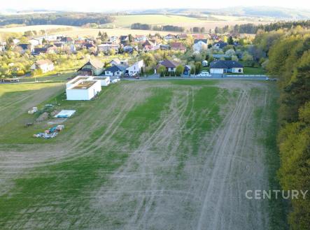Volný pozemek na okraji obce, obklopený zelení a lesem, ideální pro stavbu moderního rodinného domu s výhledem na krajinu. | Prodej - pozemek pro bydlení, 2 752 m²