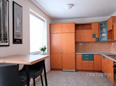 Kuchyň s dlažbou, dřevěnými skříňkami a moderním stylem, velké okno poskytuje dostatek světla. | Pronájem bytu, 2+kk, 60 m²